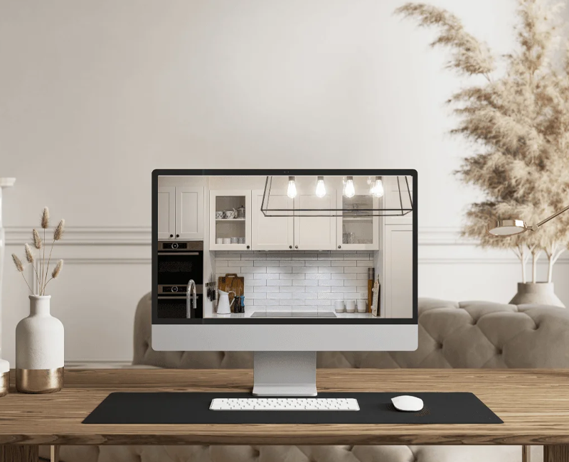 Desktop computer displaying a virtual kitchen design in a stylish home office, representing online interior e-design services